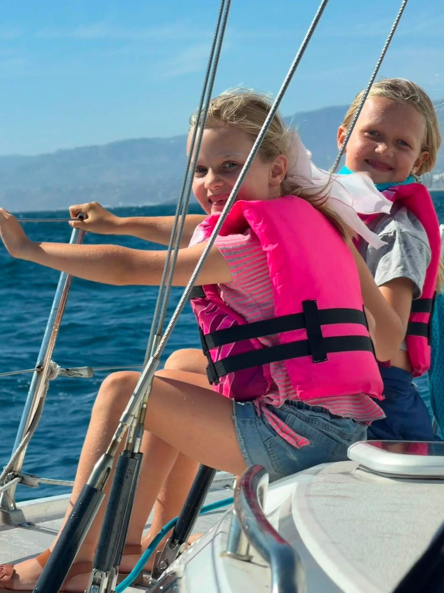 Two young sailors on the rail of a Fairwind boat
